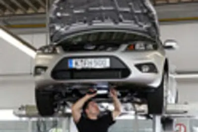 Eine Person führt Arbeiten an einem Fahrzeug in der Werkstatt durch