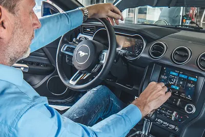 Eine Person im Auto bedient die Klimaanlage